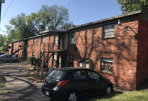 a car parked in front of a brick building